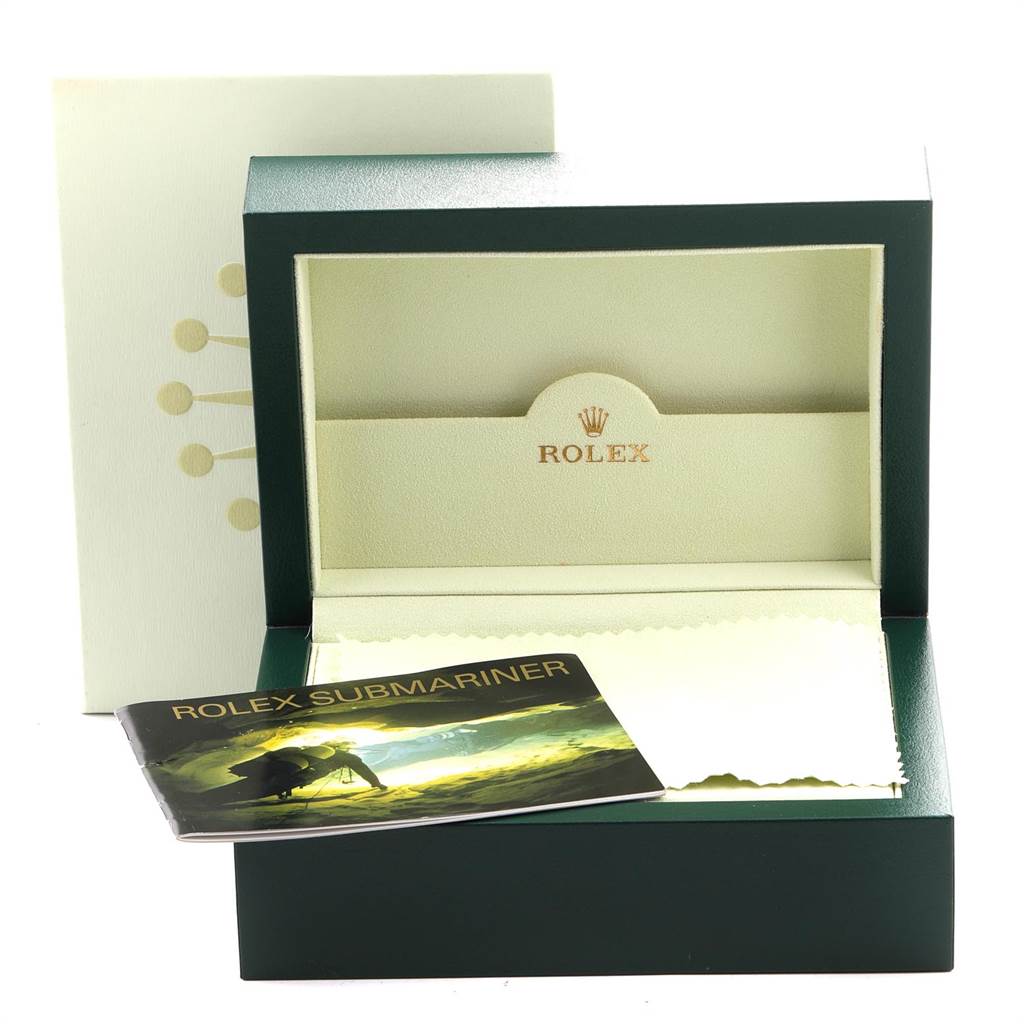 This image shows an open Rolex Submariner 16613 Men
s Steel and Gold (two tone) Blue Dial 16613 Men
s Steel and Gold (two tone) Blue Dial watch box with a booklet and a cleaning cloth.