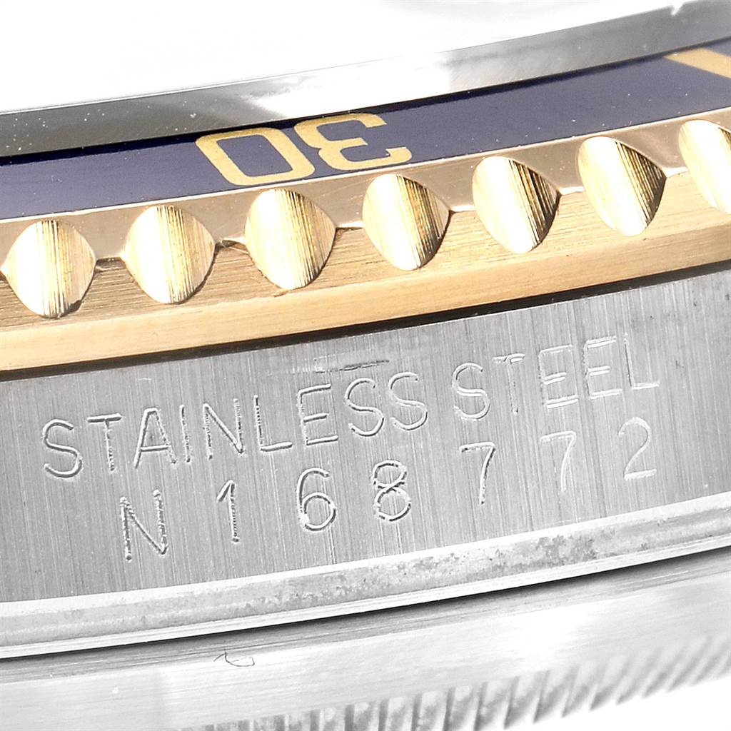 Close-up view of a Rolex Submariner 16613 Men
s Steel and Gold (two tone) Blue Dial 16613 Men
s Steel and Gold (two tone) Blue Dial model showing the watch
s bezel and the engraved "STAINLESS STEEL N168772" on the case.