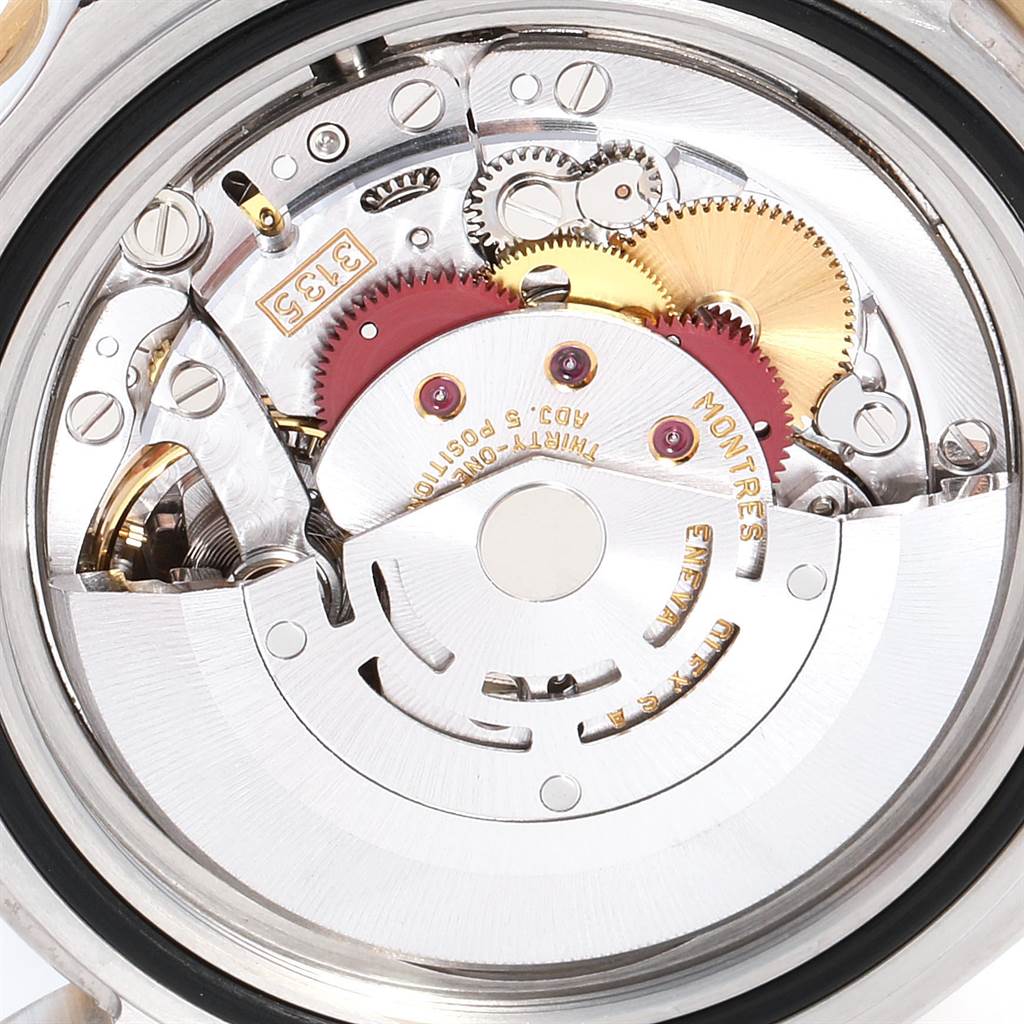 The image shows the intricate internal mechanism and gears of a Rolex Submariner 16613 Men
s Steel and Gold (two tone) Blue Dial 16613 Men
s Steel and Gold (two tone) Blue Dial watch from a close-up angle.