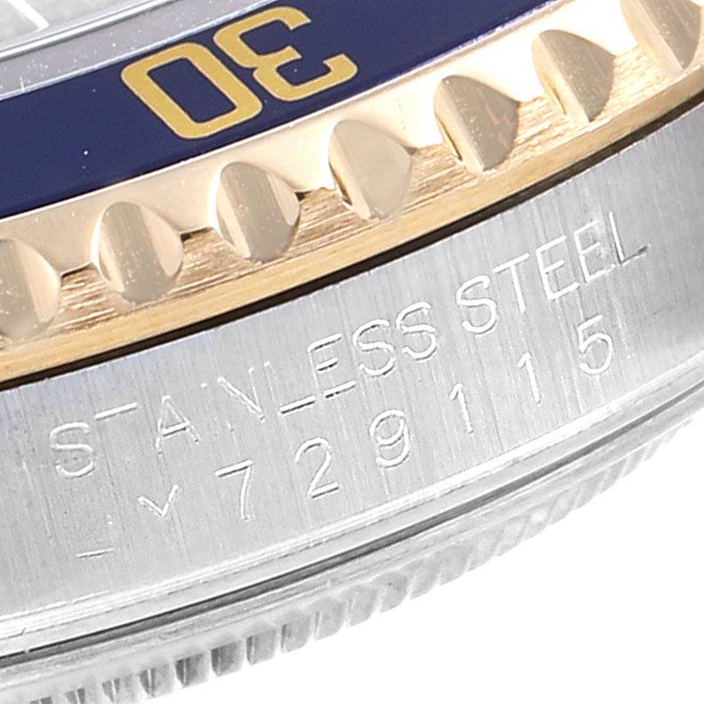 This close-up image of a Rolex Submariner 16613 Men's Steel and Gold (two tone) Blue Dial 16613 Men's Steel and Gold (two tone) Blue Dial shows the bezel with a "30" mark and the engraved stainless steel case.