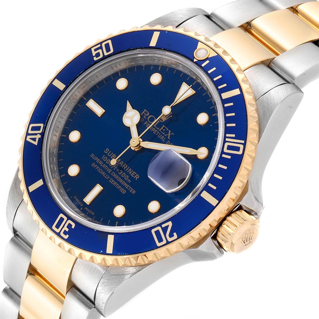 The image shows a close-up angled view of the face, bezel, and crown of a Rolex Submariner 16613 Men
s Steel and Gold (two tone) Blue Dial 16613 Men
s Steel and Gold (two tone) Blue Dial watch.