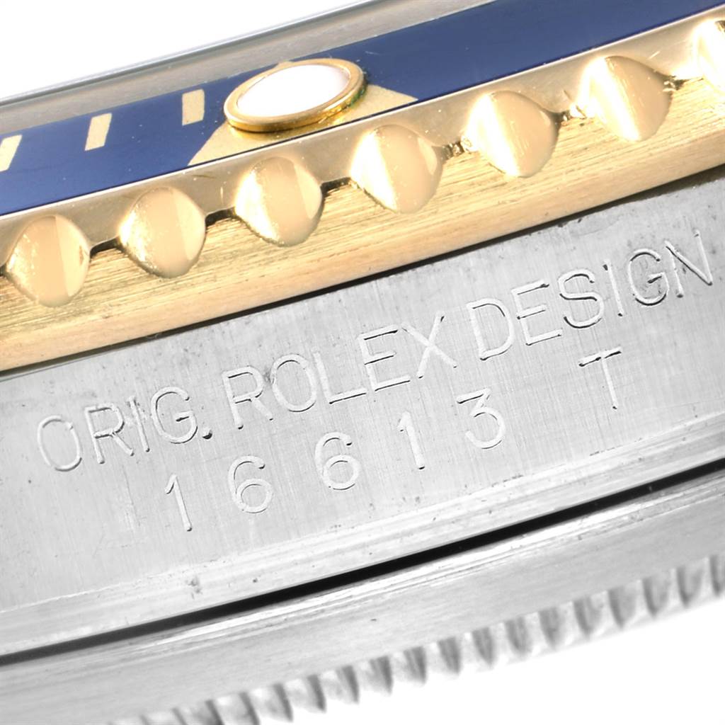 This close-up image shows the bezel and engraved outer casing of a Rolex Submariner 16613 Men
s Steel and Gold (two tone) Blue Dial 16613 Men
s Steel and Gold (two tone) Blue Dial watch, displaying the model number 16613.