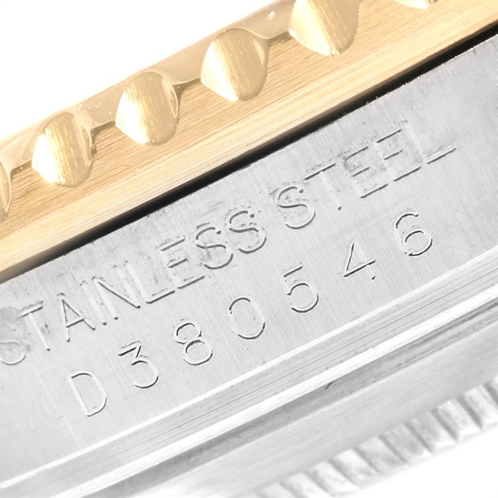 The image shows a close-up of the side of a Rolex Submariner 16613 Men
s Steel and Gold (two tone) Blue Dial 16613 Men
s Steel and Gold (two tone) Blue Dial, highlighting the engraved serial number on the stainless steel case.