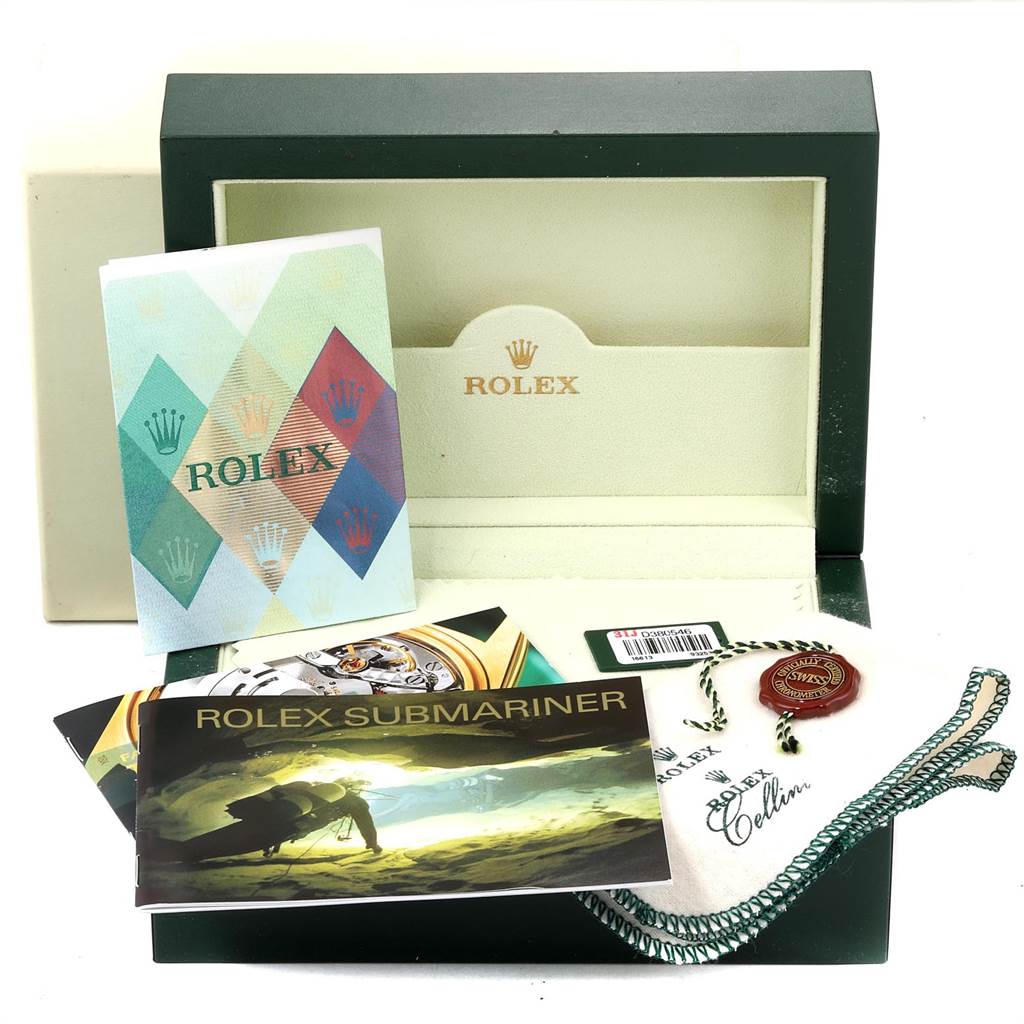 The image shows accessories for a Rolex Submariner 16613 Men
s Steel and Gold (two tone) Blue Dial 16613 Men
s Steel and Gold (two tone) Blue Dial, including its box, manuals, a hang tag, and a cleaning cloth.
