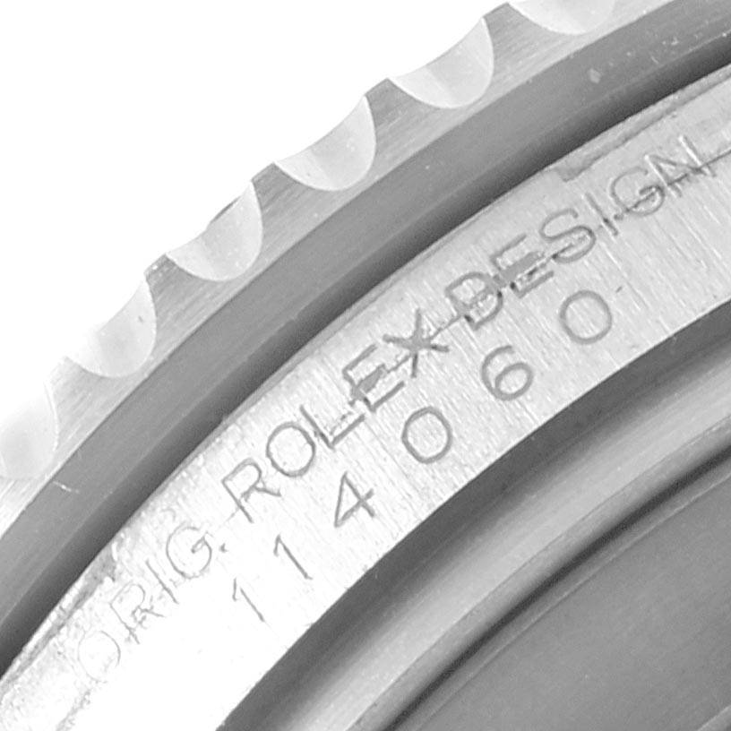 The image shows a close-up of the engraved bezel and serial number of a Rolex Submariner 114060 Men's Stainless Steel Black Dial 114060 Men's Stainless Steel Black Dial watch.