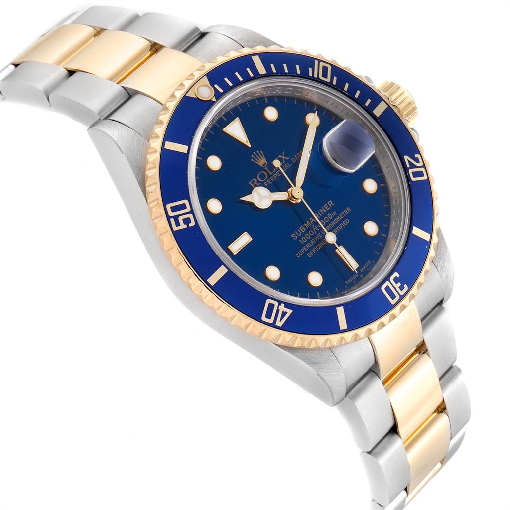 The image shows a Rolex Submariner 16613 Men
s Steel and Gold (two tone) Blue Dial 16613 Men
s Steel and Gold (two tone) Blue Dial watch at a tilted angle, highlighting its blue dial, gold bezel, and two-tone bracelet.