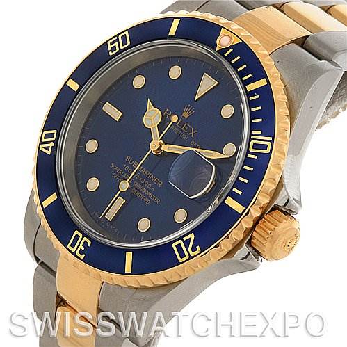 The image shows a Rolex Submariner 16613 Men's Yellow Gold Blue Dial 16613 Men's Yellow Gold Blue Dial watch with a blue dial, gold bezel, and two-tone bracelet, viewed from an angled perspective.