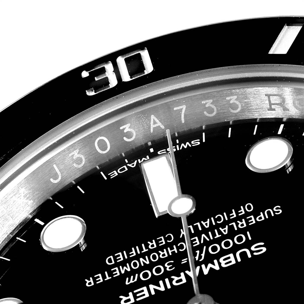 Close-up of the upper-left section of a Rolex Submariner 116610 Men
s Stainless Steel Black Dial 116610 Men
s Stainless Steel Black Dial watch face showing the dial, bezel, and part of the minute hand.