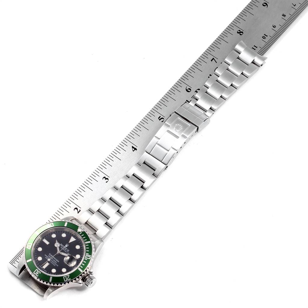 The image shows a top-down view of a Rolex Submariner 16610LV Men's Stainless Steel Black Dial 16610LV Men's Stainless Steel Black Dial watch, highlighting the face, bracelet, and clasp against a ruler.