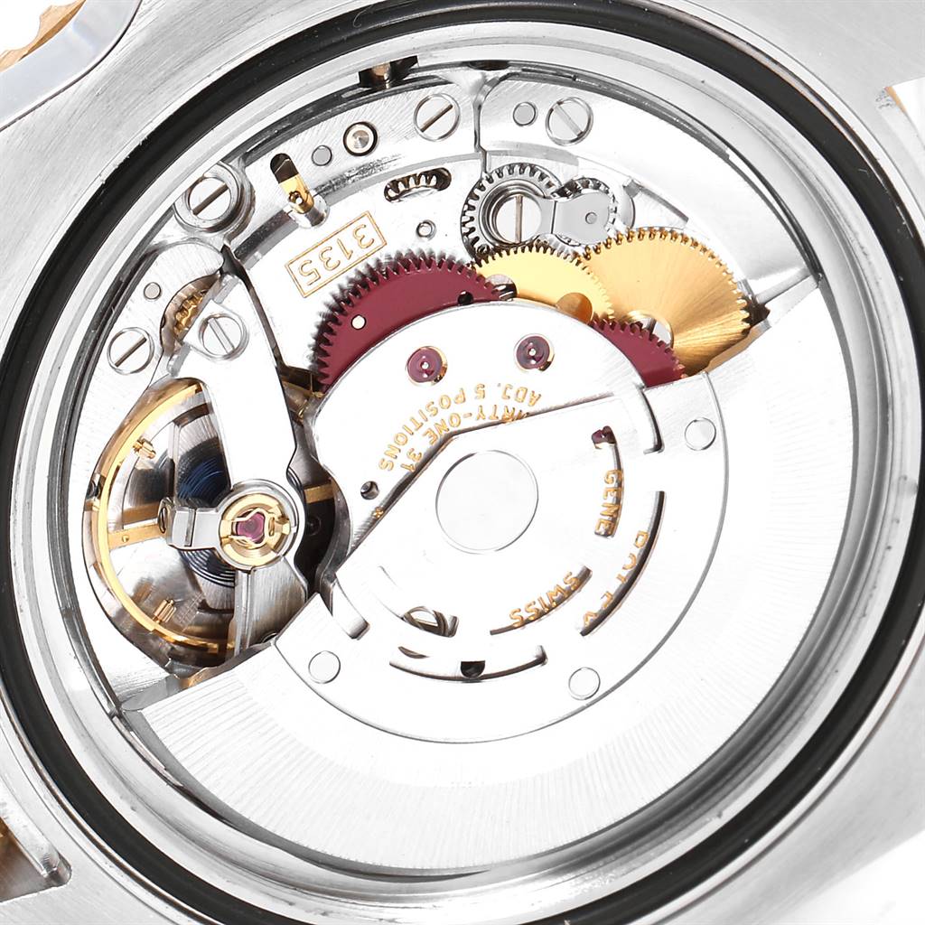 The image shows a close-up of the inner mechanical movement of the Rolex Submariner 116613 Men
s Steel and Gold (two tone) Black Dial 116613 Men
s Steel and Gold (two tone) Black Dial watch, revealing gears and intricate components.