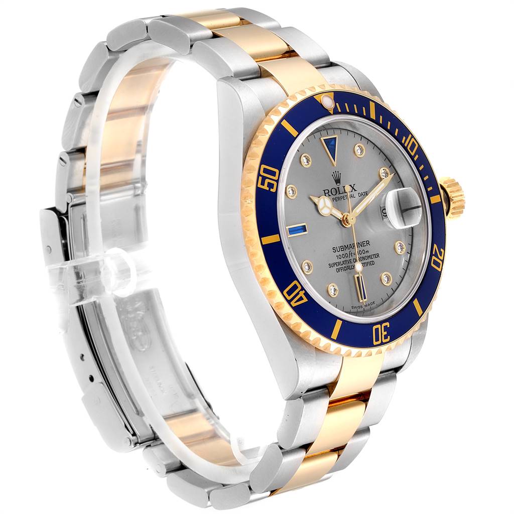 The Rolex Submariner 16613 Men
s Steel and Gold (two tone) Grey Dial 16613 Men
s Steel and Gold (two tone) Grey Dial watch is shown at an angled view, displaying its bezel, dial, crown, and two-tone bracelet.