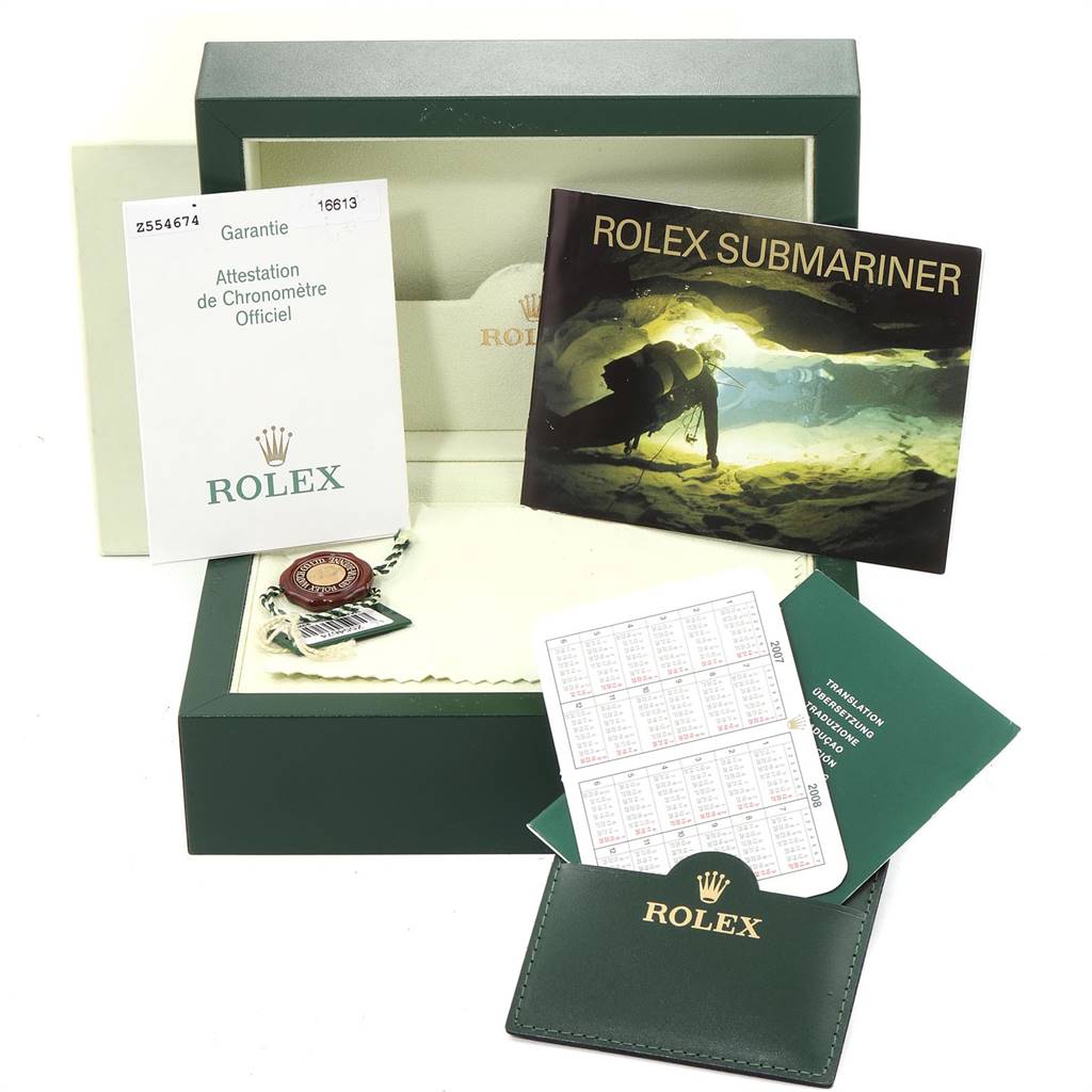 The image shows the accessories and packaging for the Rolex Submariner 16613 Men
s Steel and Gold (two tone) Blue Dial 16613 Men
s Steel and Gold (two tone) Blue Dial, including the warranty card, manual, tags, and box.