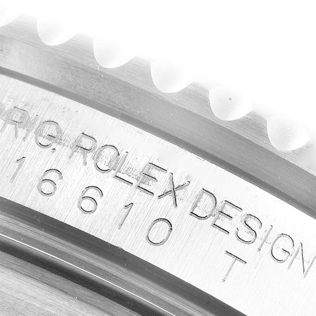 Close-up of the Rolex Submariner 16610 Men
s Stainless Steel Black Dial 16610 Men
s Stainless Steel Black Dial model
s inner bezel, showing the engraving "ORIG. ROLEX DESIGN 16610 T".