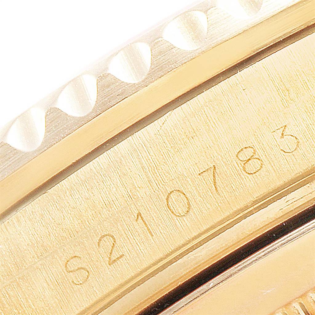 The image shows a close-up of the serial number and the edge of the bezel of a Rolex Submariner 16618 Men's Yellow Gold Blue Dial 16618 Men's Yellow Gold Blue Dial watch.