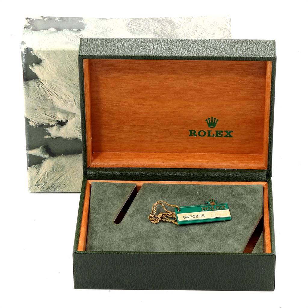 The image shows an open Rolex Submariner 16800 Men
s Stainless Steel Black Dial 16800 Men
s Stainless Steel Black Dial watch box from the top, containing a tag and featuring green and wooden interior elements.