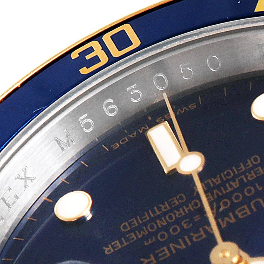 The image shows a close-up of the Rolex Submariner 16613 Men
s Steel and Gold (two tone) Blue Dial 16613 Men
s Steel and Gold (two tone) Blue Dial watch dial, part of the bezel, and the minute hand.