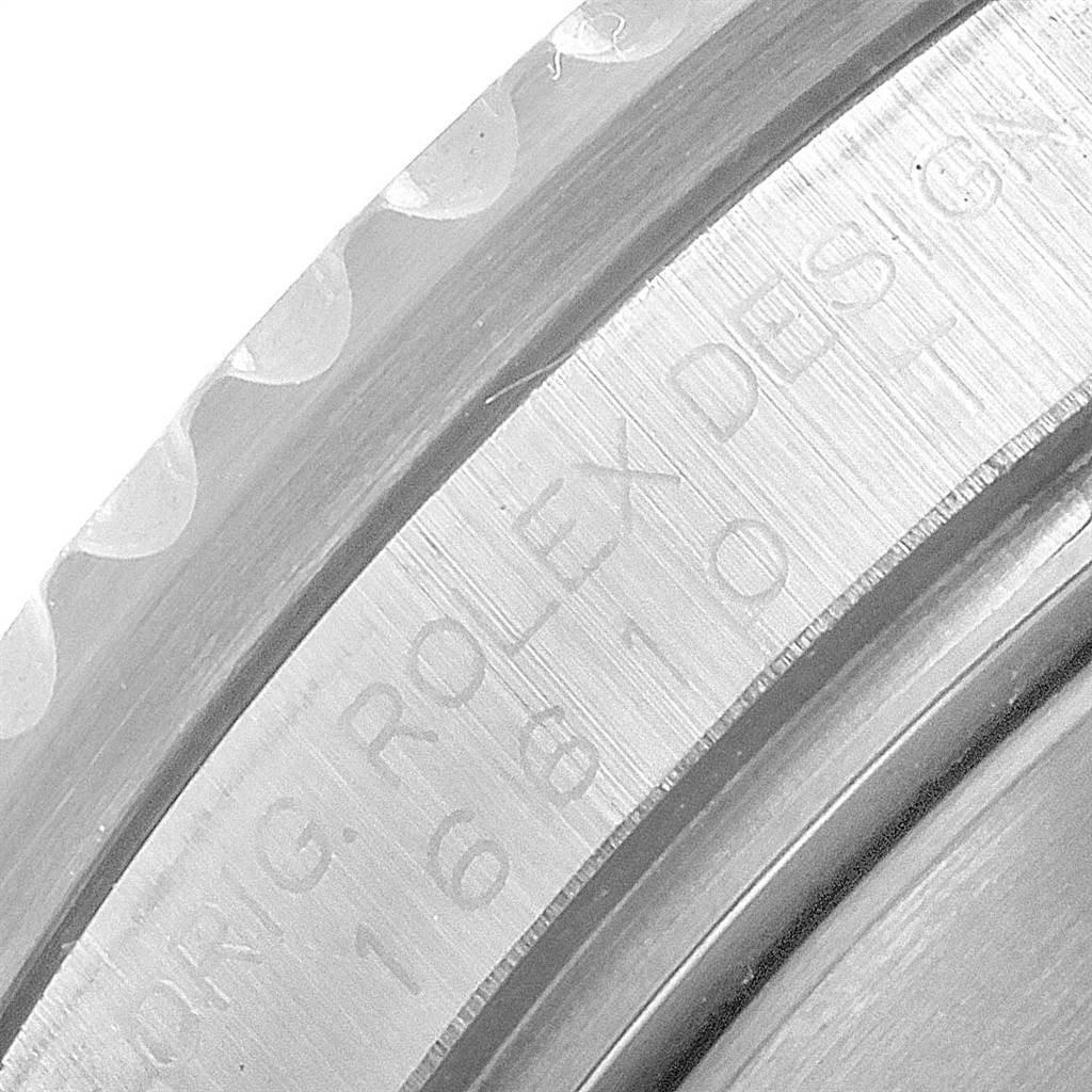 The image shows a close-up of a Rolex Submariner 16610 Men
s Stainless Steel Black Dial 16610 Men
s Stainless Steel Black Dial
s bezel and the engraved "ROLEX DESIGN" text with the model number.