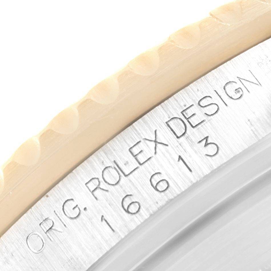 The image shows a close-up of the bezel and case side of a Rolex Submariner 16613 Men
s Steel and Gold (two tone) Blue Dial 16613 Men
s Steel and Gold (two tone) Blue Dial, revealing the model number 16613 and "ORIG. ROLEX DESIGN."