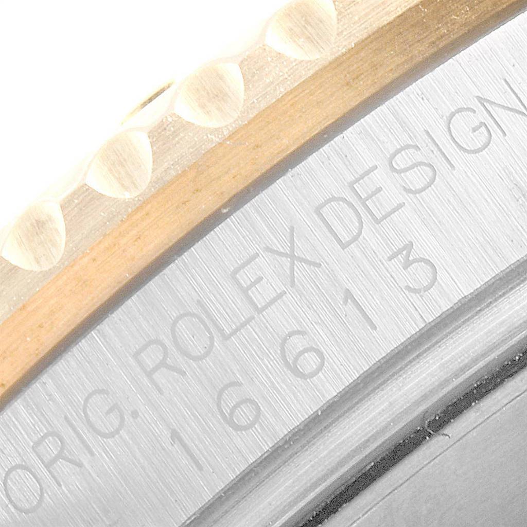 This close-up image of the Rolex Submariner 16613 Men
s Steel and Gold (two tone) Blue Dial 16613 Men
s Steel and Gold (two tone) Blue Dial watch shows the engraved model number on its case and part of the bezel.