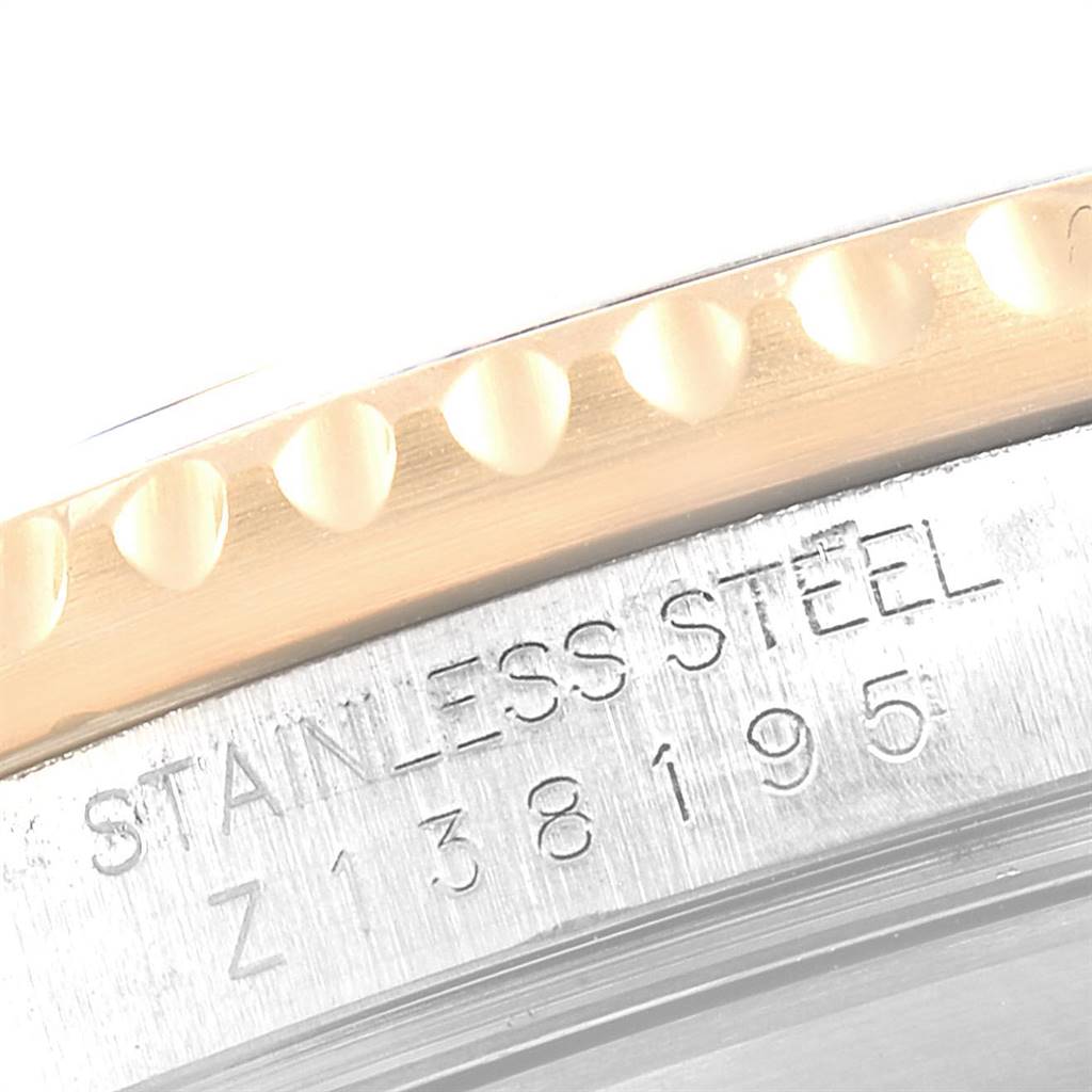 The image shows a close-up of the bezel and the engraved serial number on the stainless steel case of a Rolex Submariner 16613 Men
s Steel and Gold (two tone) Grey Dial 16613 Men
s Steel and Gold (two tone) Grey Dial watch.