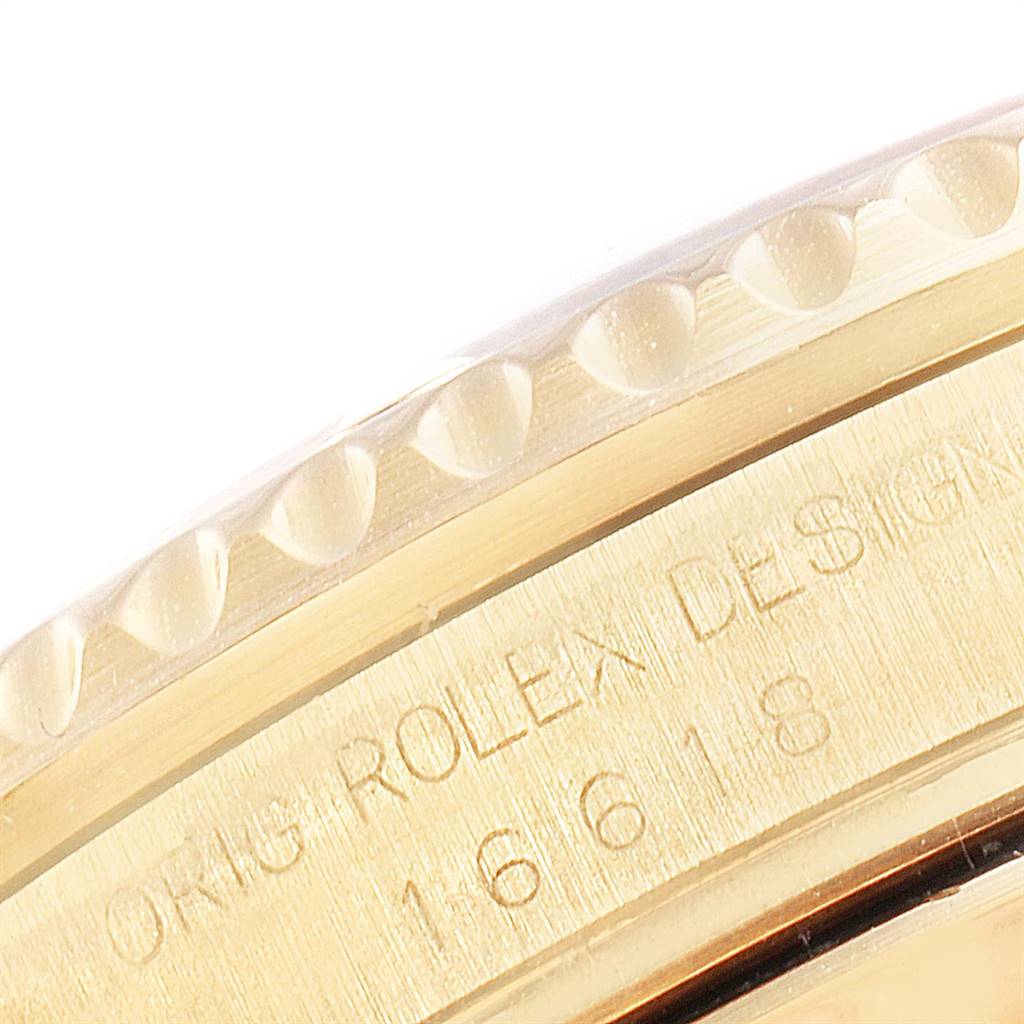 This image shows a close-up of the side of a Rolex Submariner 16618 Men
s Yellow Gold Black Dial 16618 Men
s Yellow Gold Black Dial watch, highlighting the bezel and engraving.
