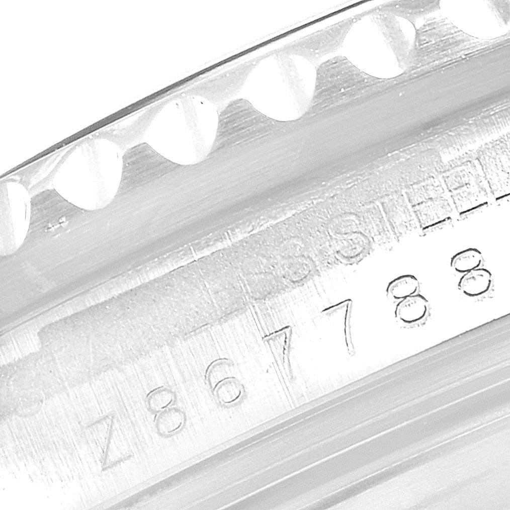 The image shows the engraved serial number and part of the bezel of a Rolex Submariner 16610 Men
s Stainless Steel Black Dial 16610 Men
s Stainless Steel Black Dial watch.