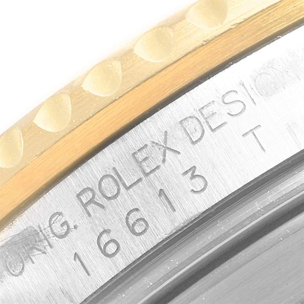 This close-up image shows the model number engraving and edge of the bezel of a Rolex Submariner 16613 Men's Steel and Gold (two tone) Black Dial 16613 Men's Steel and Gold (two tone) Black Dial.