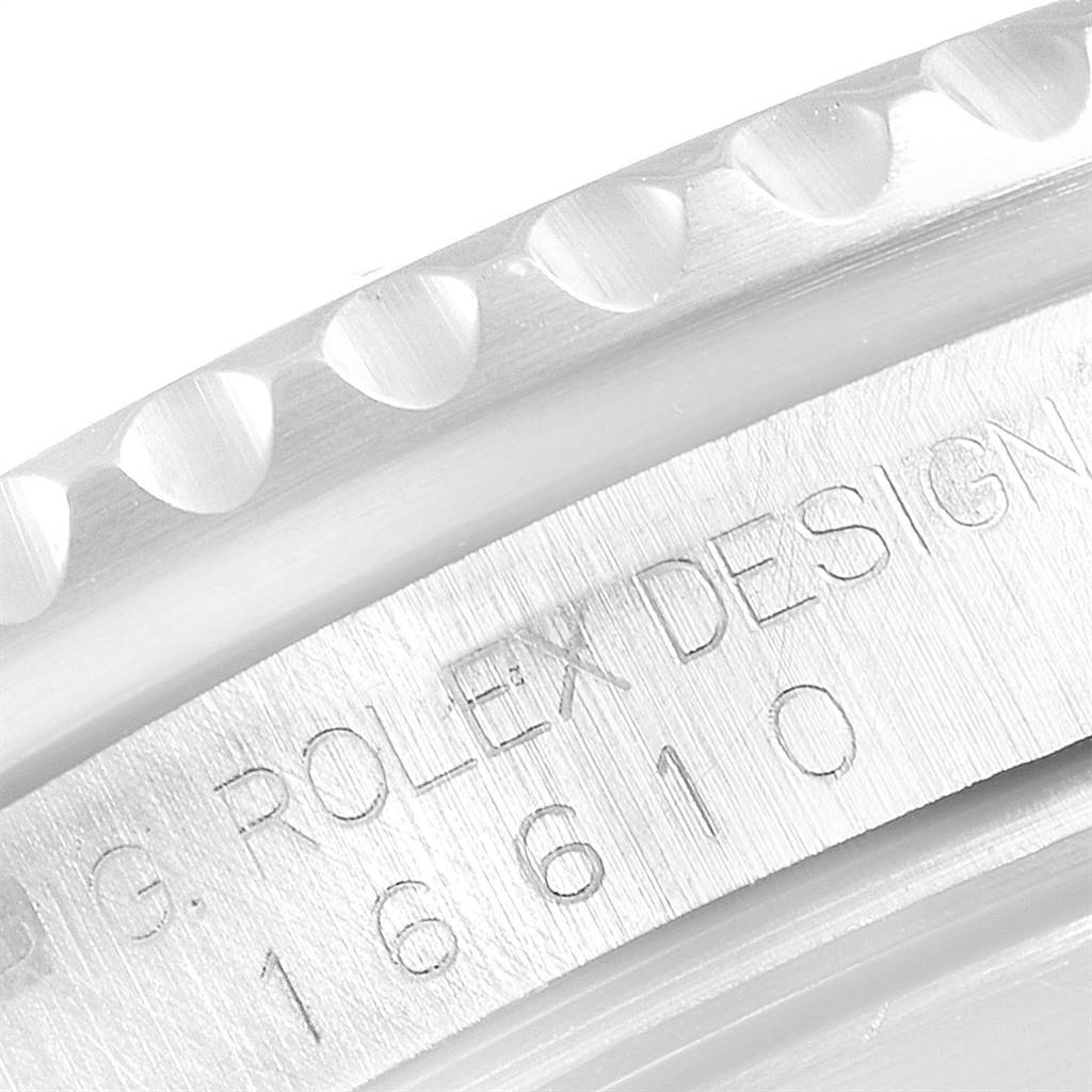The image shows a close-up of the engraved serial number and part of the bezel on the side of a Rolex Submariner 16610 Men
s Stainless Steel Black Dial 16610 Men
s Stainless Steel Black Dial watch.