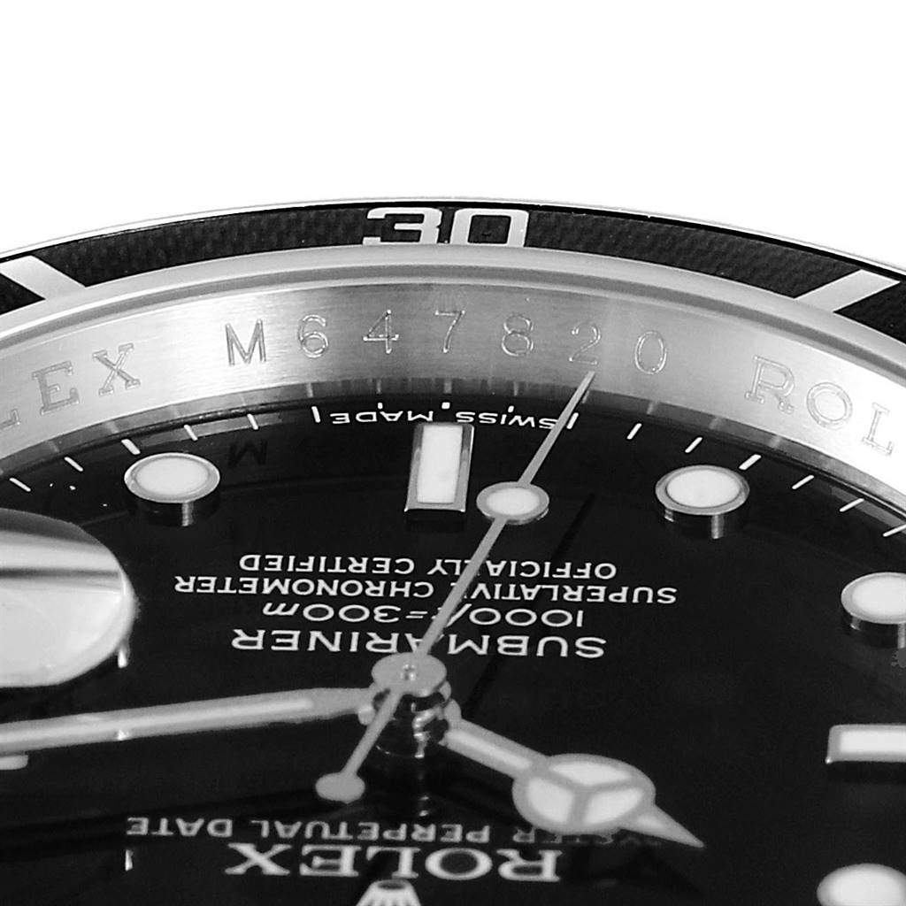 This close-up image of a Rolex Submariner 16610 Men
s Stainless Steel Black Dial 16610 Men
s Stainless Steel Black Dial watch features the bezel, part of the dial, and the serial number engraving.