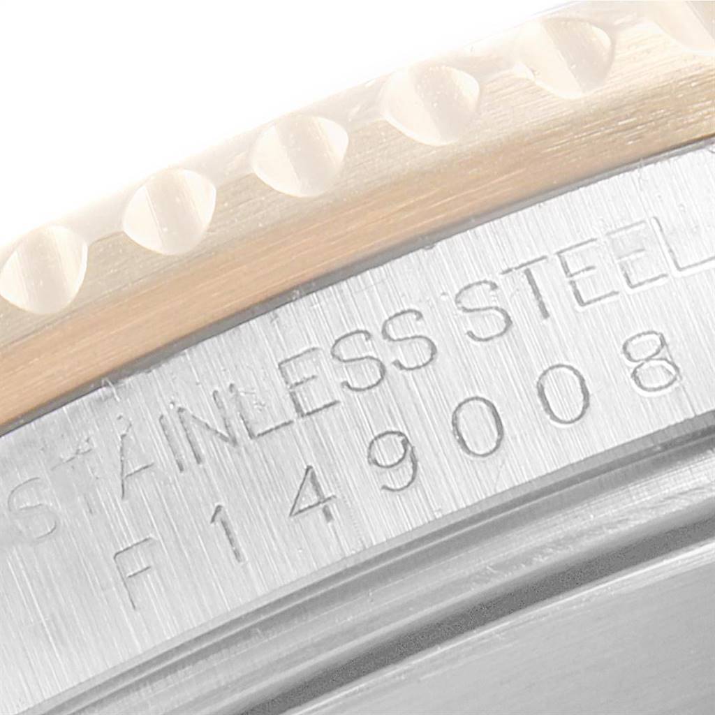 The image shows a close-up of the side of a Rolex Submariner 16613 Men
s Steel and Gold (two tone) Black Dial 16613 Men
s Steel and Gold (two tone) Black Dial watch, highlighting the serial number engraving and part of the bezel.