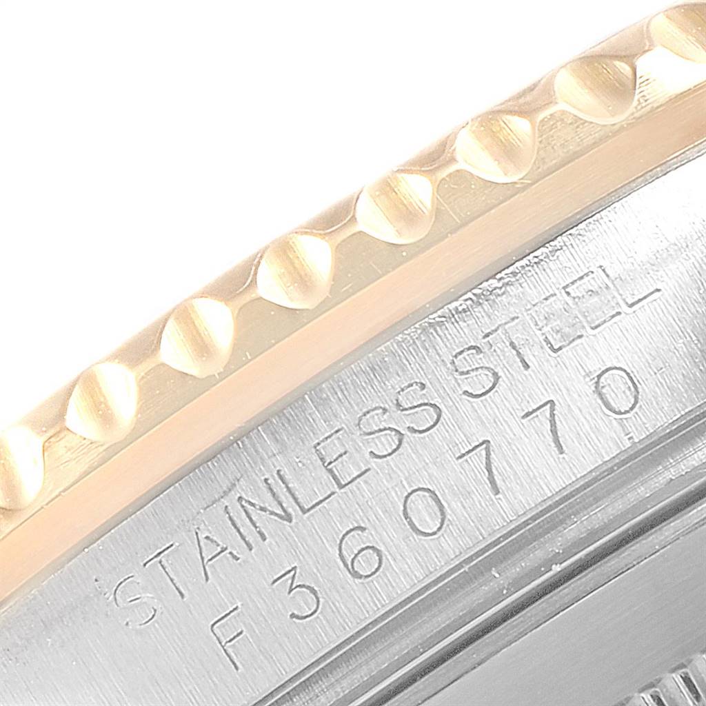 The image shows a close-up of the side of a Rolex Submariner 16613 Men
s Steel and Gold (two tone) Grey Dial 16613 Men
s Steel and Gold (two tone) Grey Dial watch, highlighting the case with engraved serial numbers.