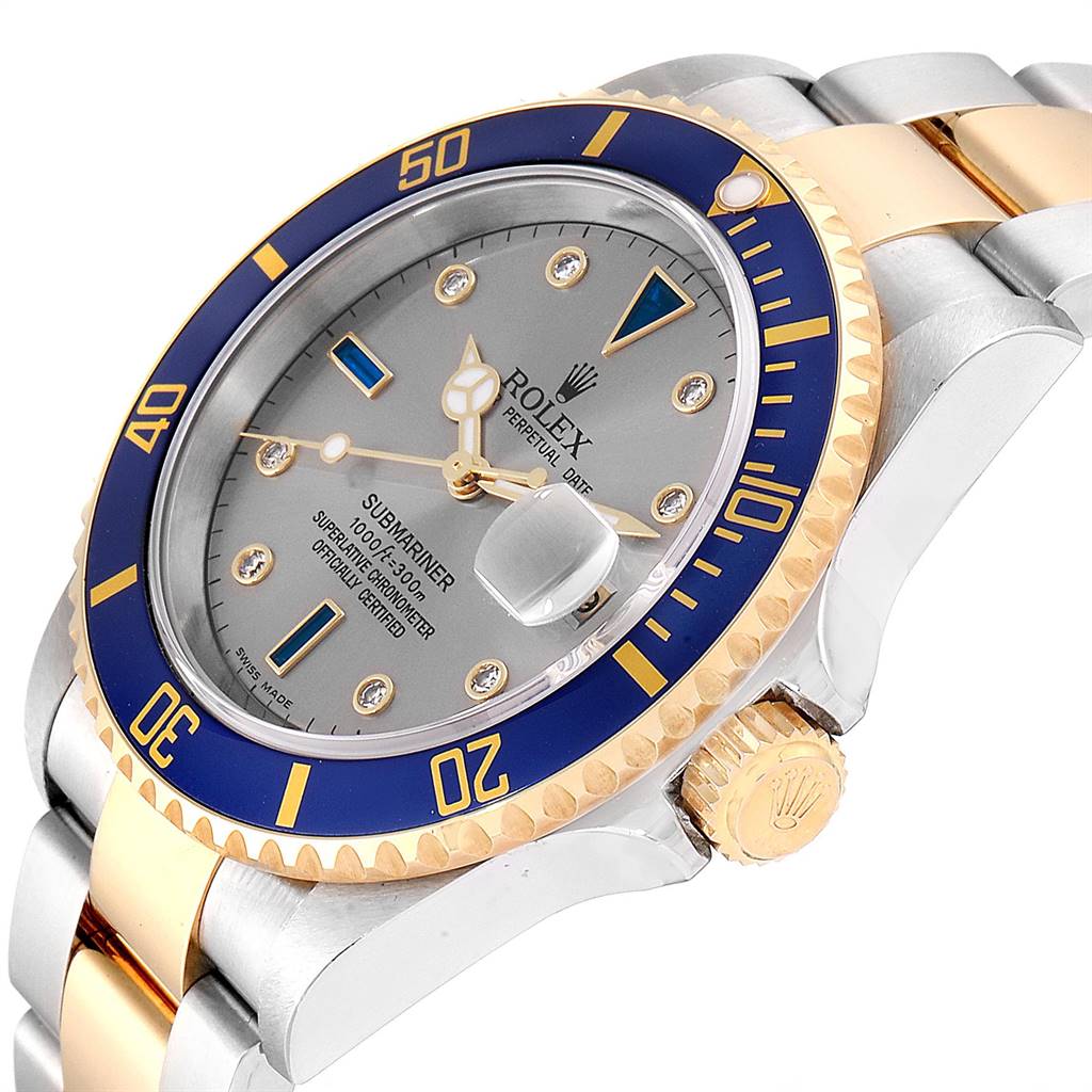 The image shows a Rolex Submariner 16613 Men
s Steel and Gold (two tone) Grey Dial 16613 Men
s Steel and Gold (two tone) Grey Dial angled to display its bezel, dial, crown, and part of the bracelet.