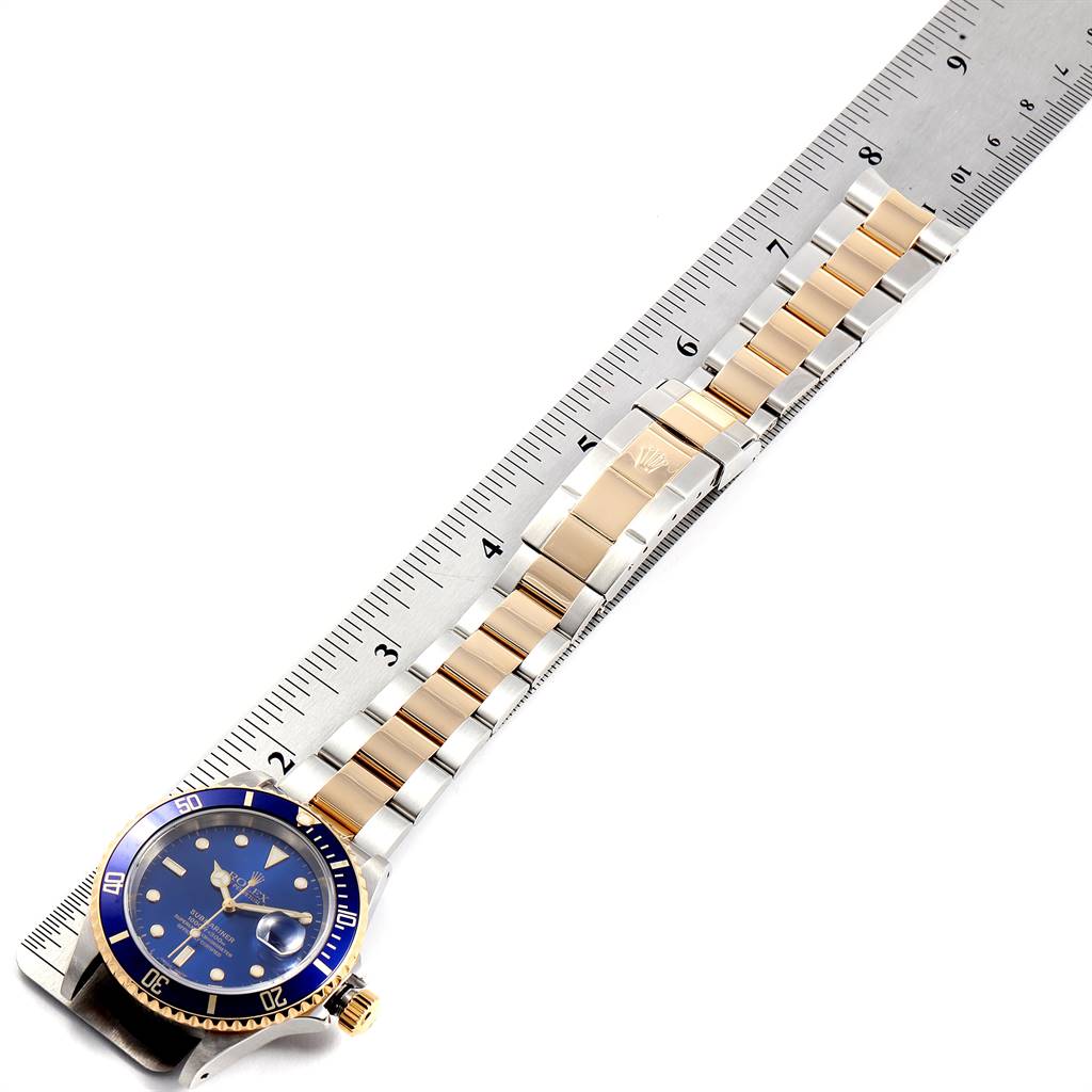 The image shows a top-down view of the Rolex Submariner 16613 Men
s Steel and Gold (two tone) Blue Dial 16613 Men
s Steel and Gold (two tone) Blue Dial watch, highlighting its blue dial, two-tone bracelet, and clasp.