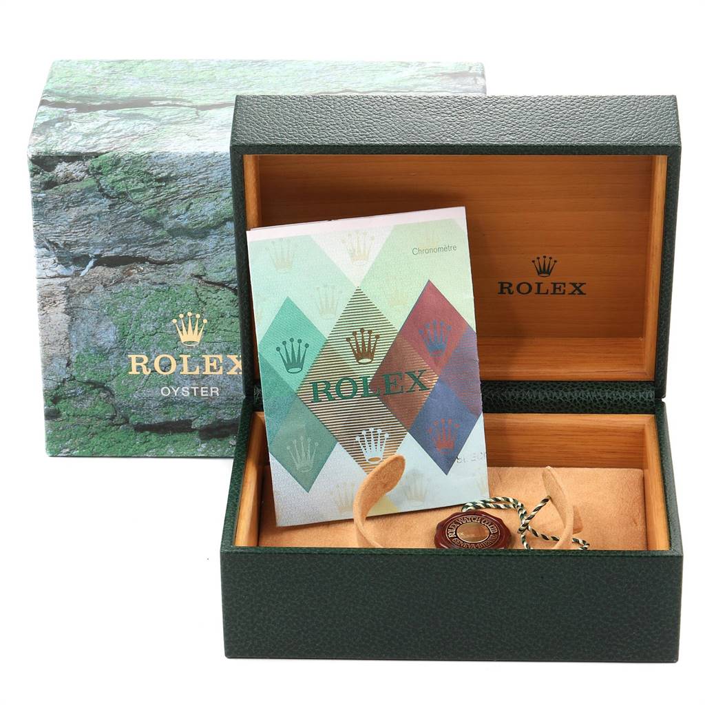 This image shows an open Rolex Submariner 16613 Men
s Steel and Gold (two tone) Blue Dial 16613 Men
s Steel and Gold (two tone) Blue Dial watch box with a booklet and accessories inside, along with the outer packaging.