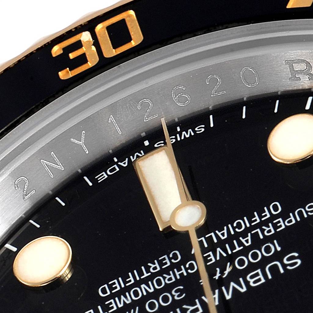 This close-up image of the Rolex Submariner 116613 Men's Steel and Gold (two tone) Black Dial 116613 Men's Steel and Gold (two tone) Black Dial shows part of the dial, bezel, and part of the minute hand.