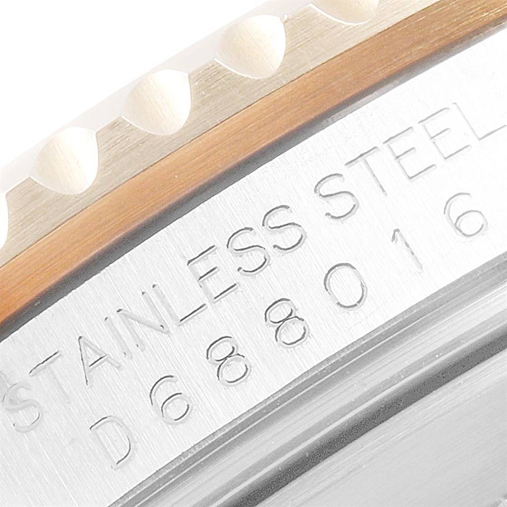 The image shows a close-up of the side view of a Rolex Submariner 16613 Men
s Steel and Gold (two tone) Blue Dial 16613 Men
s Steel and Gold (two tone) Blue Dial watch, focusing on the engraved case with part of the bezel visible.