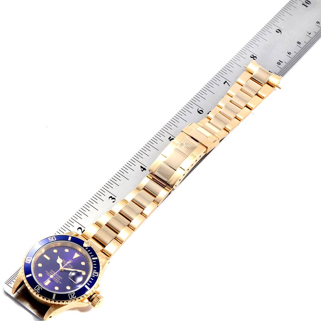 The image shows a top-down view of a Rolex Submariner 16618 Men's Yellow Gold Blue Dial 16618 Men's Yellow Gold Blue Dial watch, displaying the face, bezel, and full bracelet alongside a ruler.