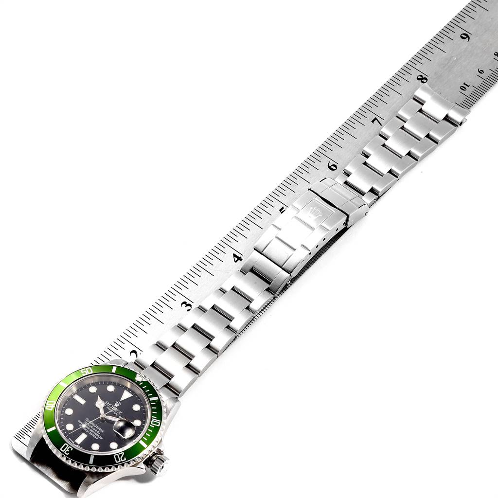 The watch, a Rolex Submariner 16610LV Men
s Stainless Steel Black Dial 16610LV Men
s Stainless Steel Black Dial, is shown from a top-down angle with its full metal bracelet extended alongside a ruler.