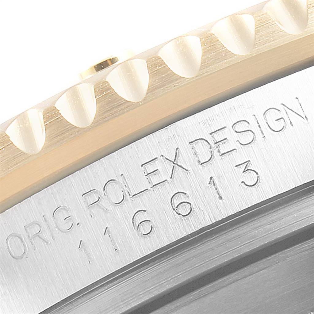 This close-up image shows the engraved details and bezel edge of a Rolex Submariner 116613 Men
s Steel and Gold (two tone) Blue Dial 116613 Men
s Steel and Gold (two tone) Blue Dial watch, including "ROLEX DESIGN 16613".