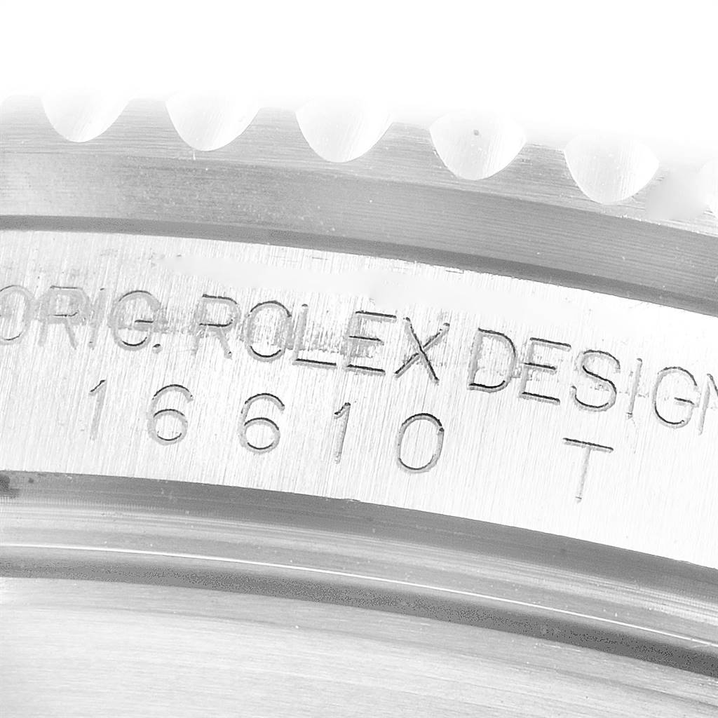 This close-up image shows the engraved design and model number 16610T on the bezel of a Rolex Submariner 16610 Men
s Stainless Steel Black Dial 16610 Men
s Stainless Steel Black Dial.