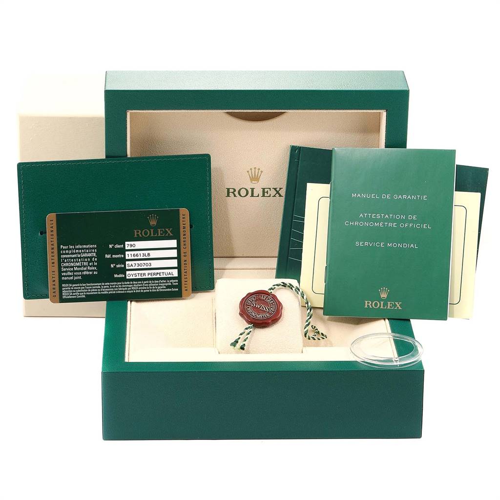 The image shows a packaging box with a warranty card, manuals, and tag for a Rolex Submariner 116613 Men
s Steel and Gold (two tone) Blue Dial 116613 Men
s Steel and Gold (two tone) Blue Dial watch.