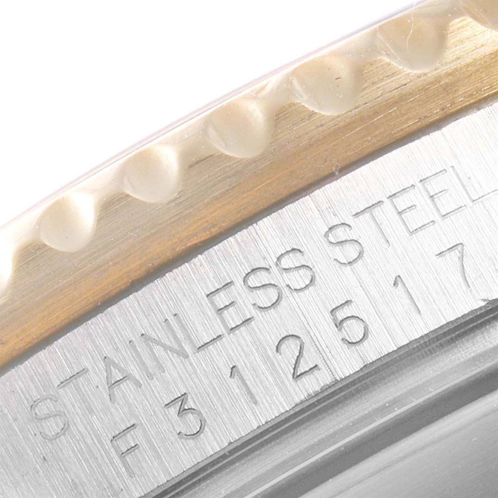 The image shows a close-up of the case back and bezel of a Rolex Submariner 16613 Men
s Steel and Gold (two tone) Blue Dial 16613 Men
s Steel and Gold (two tone) Blue Dial watch, highlighting the stainless steel engraving and the watch
s serial number.