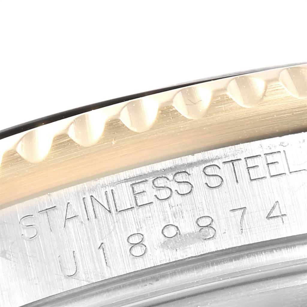 The image shows a close-up of the bezel and part of the stainless steel case with engravings on a Rolex Submariner 16613 Men's Steel and Gold (two tone) Black Dial 16613 Men's Steel and Gold (two tone) Black Dial watch.