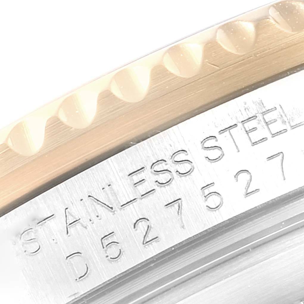 This close-up image of a Rolex Submariner 16613 Men's Steel and Gold (two tone) Black Dial 16613 Men's Steel and Gold (two tone) Black Dial shows part of the bezel and the case back with engraved text indicating stainless steel.