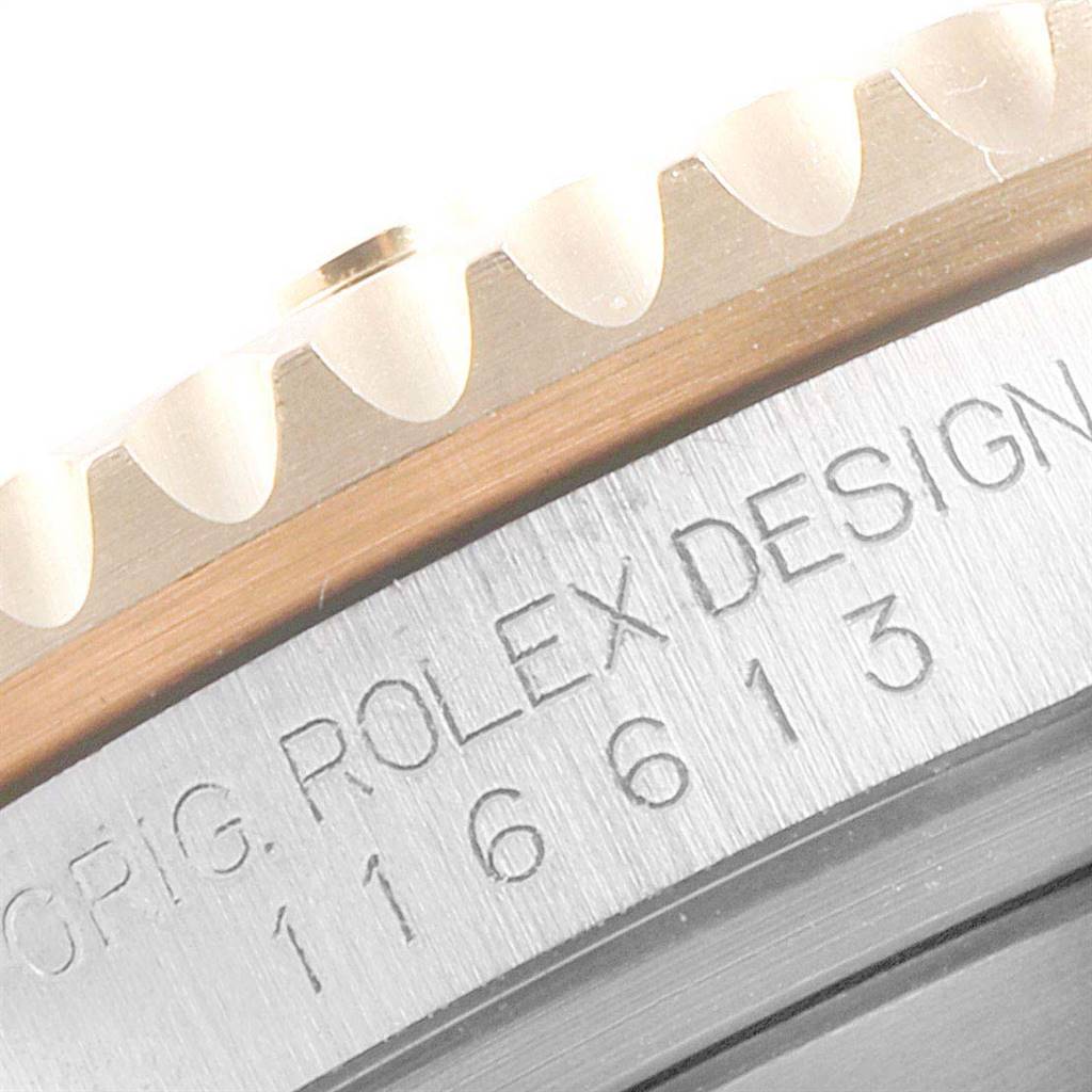 The image shows a close-up of the edge of the bezel and the engraved side of a Rolex Submariner 116613 Men
s Steel and Gold (two tone) Blue Dial 116613 Men
s Steel and Gold (two tone) Blue Dial watch.