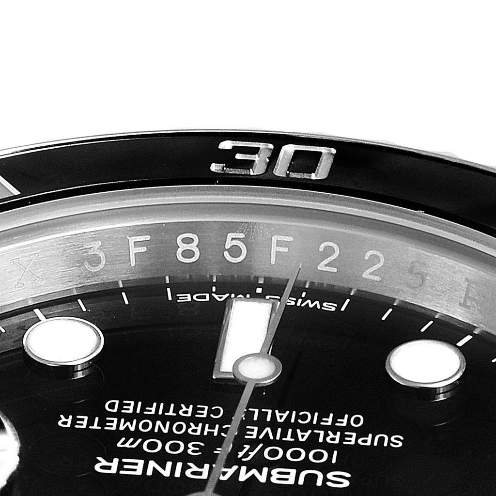 The image shows a close-up of the Rolex Submariner 116610 Men
s Stainless Steel Black Dial 116610 Men
s Stainless Steel Black Dial watch dial, including the bezel and part of the face with text and markers.