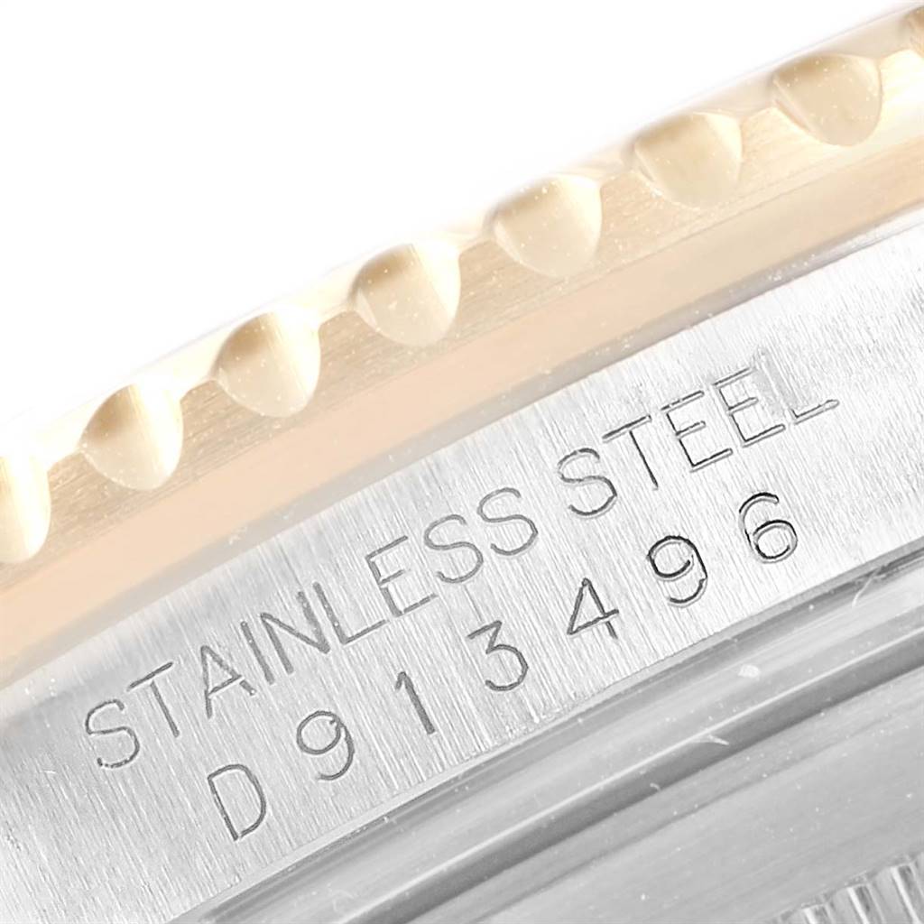 This close-up shows the engraved serial number and part of the bezel of the Rolex Submariner 16613 Men
s Steel and Gold (two tone) Black Dial 16613 Men
s Steel and Gold (two tone) Black Dial watch.
