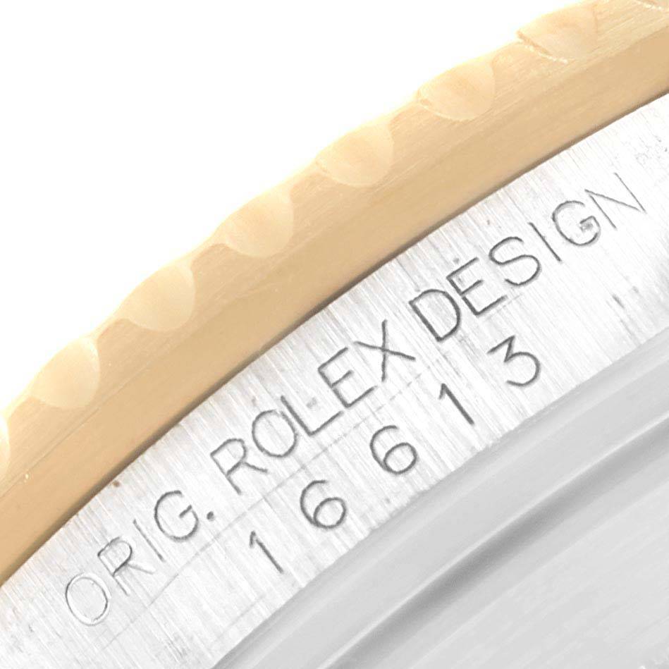 The image shows a close-up of the etched model number and design details on the case side of a Rolex Submariner 16613 Men
s Steel and Gold (two tone) Champagne Dial 16613 Men
s Steel and Gold (two tone) Champagne Dial.