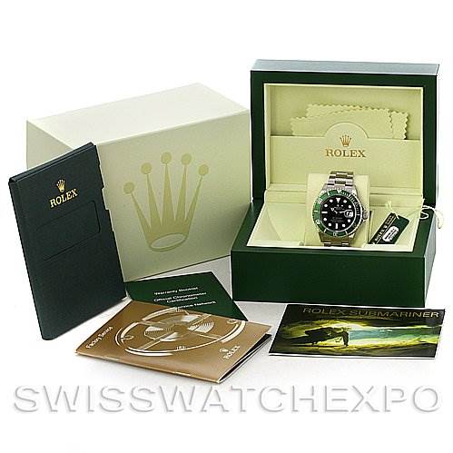The image shows a Rolex Submariner 16610LV Men's Stainless Steel Black Dial 16610LV Men's Stainless Steel Black Dial watch, its box, warranty card, instruction booklets, and a polishing cloth.