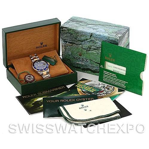 This image shows a Rolex Submariner 16613 Men's Yellow Gold Blue Dial 16613 Men's Yellow Gold Blue Dial watch and its accessories, including the box, manuals, warranty card, and cleaning cloth.